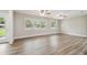 Inviting living room featuring wood-look floors, multiple windows, and two ceiling fans at 1410 Moss Laden Ct, Brandon, FL 33511