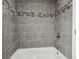 A shower with gray tiling and decorative accent trim at 1410 Moss Laden Ct, Brandon, FL 33511
