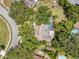 Aerial view of the property featuring mature trees and a pool at 1695 Cinnamon Ln, Dunedin, FL 34698
