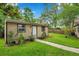Backyard shed with grassy lawn, brick walkway, and landscaping at 1695 Cinnamon Ln, Dunedin, FL 34698