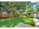Wide shot of backyard with grassy lawn and privacy fence at 1695 Cinnamon Ln, Dunedin, FL 34698