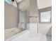 Bright bathroom featuring a soaking tub, glass enclosed shower, and tile flooring at 1695 Cinnamon Ln, Dunedin, FL 34698