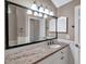 Bathroom featuring granite countertops, a large mirror, and white cabinetry at 1695 Cinnamon Ln, Dunedin, FL 34698