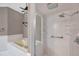 Bathroom with a bathtub and separate shower, equipped with grab bars for accessibility at 1695 Cinnamon Ln, Dunedin, FL 34698