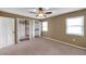 Neutral bedroom with a ceiling fan, carpet, and three closets for ample storage at 1695 Cinnamon Ln, Dunedin, FL 34698