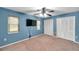 Blue bedroom featuring a ceiling fan, two windows, and double closets at 1695 Cinnamon Ln, Dunedin, FL 34698