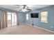 Bedroom featuring a ceiling fan, a sliding glass door, and a mounted TV at 1695 Cinnamon Ln, Dunedin, FL 34698