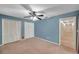 Bedroom featuring a ceiling fan and closets opening up to a hallway at 1695 Cinnamon Ln, Dunedin, FL 34698