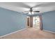 Blue bedroom with a ceiling fan, a door to a lanai, and a neutral carpet at 1695 Cinnamon Ln, Dunedin, FL 34698