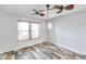 Clean bedroom with wood-look floors, window, and ceiling fan at 1695 Cinnamon Ln, Dunedin, FL 34698