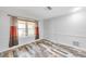 Cozy bedroom with wood-style flooring, neutral paint, and a large window providing natural light for a relaxing atmosphere at 1695 Cinnamon Ln, Dunedin, FL 34698