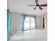 Large bedroom with tile flooring, vaulted ceilings, a ceiling fan, and access to the patio at 1695 Cinnamon Ln, Dunedin, FL 34698