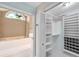 Neat walk-in closet with custom shelving adjacent to the bright primary bathroom at 1695 Cinnamon Ln, Dunedin, FL 34698