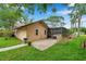 Rear exterior of house with screened-in pool, brick patio, and lush backyard at 1695 Cinnamon Ln, Dunedin, FL 34698