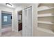 Hallway leading to bath and bedroom with tile flooring and built-in shelving at 1695 Cinnamon Ln, Dunedin, FL 34698