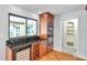 Kitchenette area featuring custom cabinets, built-in appliances, granite counter and wine cooler at 1695 Cinnamon Ln, Dunedin, FL 34698
