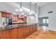 Open kitchen design with wood cabinets, granite countertop, and wood flooring at 1695 Cinnamon Ln, Dunedin, FL 34698