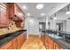Well-lit kitchen featuring wood cabinets and a granite counter with stainless steel sink at 1695 Cinnamon Ln, Dunedin, FL 34698