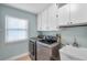 Convenient laundry room featuring modern appliances, a utility sink, and storage at 1695 Cinnamon Ln, Dunedin, FL 34698