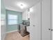 Clean laundry room with stainless steel washer and dryer and storage cabinets at 1695 Cinnamon Ln, Dunedin, FL 34698