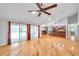 Open floor plan living room with hardwood floors, fireplace, and seamless access to the kitchen at 1695 Cinnamon Ln, Dunedin, FL 34698