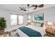Cozy main bedroom with wood-look floors, natural light, ceiling fan, and modern decor at 1695 Cinnamon Ln, Dunedin, FL 34698