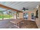 Covered patio area boasts brick pavers, ceiling fan, and views of the pool and backyard at 1695 Cinnamon Ln, Dunedin, FL 34698
