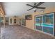 Covered brick paver patio with ceiling fans, a wall-mounted TV, and views of the pool and lush landscaping at 1695 Cinnamon Ln, Dunedin, FL 34698