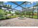 Spa located in a screened-in pool area featuring brick pavers and a serene, private backyard setting at 1695 Cinnamon Ln, Dunedin, FL 34698