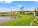 Beautiful view of the townhomes overlooking the pond with palm trees and lush green landscaping at 17527 Stinchar Dr, Land O Lakes, FL 34638