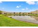 Beautiful view of a pond surrounded by well-maintained homes and lush green lawns at 17527 Stinchar Dr, Land O Lakes, FL 34638