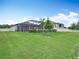 Backyard featuring a lush green lawn and white picket fence with a view of the home's screened-in lanai at 18079 Romanesque Ct, Spring Hill, FL 34610