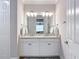 Bathroom with double vanity, granite countertops, updated lighting, and a view into the bedroom at 18079 Romanesque Ct, Spring Hill, FL 34610