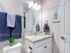 Bathroom vanity with granite countertop, decorative mirror, and towel rack with gray and blue towels at 18079 Romanesque Ct, Spring Hill, FL 34610