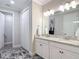 Bathroom featuring a granite countertop vanity with double sinks, and a view into the walk-in closet at 18079 Romanesque Ct, Spring Hill, FL 34610