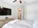 Bedroom with a large TV, ensuite bathroom, and a closet with white doors at 18079 Romanesque Ct, Spring Hill, FL 34610