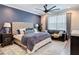Spacious bedroom with a large bed, accent wall, ceiling fan, and a comfortable sitting area at 18079 Romanesque Ct, Spring Hill, FL 34610
