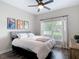 Cozy bedroom with a queen bed, a ceiling fan, and a large window that provides plenty of natural light at 18079 Romanesque Ct, Spring Hill, FL 34610