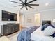 Bedroom featuring a large TV on a dresser, with a view to an ensuite bathroom at 18079 Romanesque Ct, Spring Hill, FL 34610