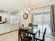 Dining area with wood table, views of living room and covered pool area with access through sliding glass doors at 18079 Romanesque Ct, Spring Hill, FL 34610