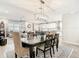 Open-concept dining area with a modern light fixture, seamlessly connecting to the living room and kitchen at 18079 Romanesque Ct, Spring Hill, FL 34610