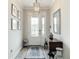 Elegant entryway featuring decorative mirrors, a wooden table, and stylish light fixture creating a warm ambiance at 18079 Romanesque Ct, Spring Hill, FL 34610