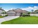 Beautiful single-story home featuring a well-manicured lawn and a two-car garage with decorative stone accents at 18079 Romanesque Ct, Spring Hill, FL 34610