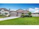 Charming single-story home featuring a well-manicured lawn, three-car garage, and stone accents at 18079 Romanesque Ct, Spring Hill, FL 34610