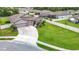 Aerial view showcases lush landscaping, a three-car garage, and a long driveway at 18079 Romanesque Ct, Spring Hill, FL 34610