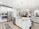 Modern kitchen view with stainless steel appliances, granite island, and an open layout to the dining and living areas at 18079 Romanesque Ct, Spring Hill, FL 34610