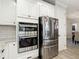 Kitchen showing stainless steel appliances, oven and refrigerator, and white cabinets and a view to the dining room at 18079 Romanesque Ct, Spring Hill, FL 34610