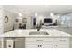 Open concept kitchen featuring granite island, stainless dishwasher, and seamless connection to living and dining areas at 18079 Romanesque Ct, Spring Hill, FL 34610