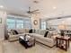 Spacious living room featuring a large sofa, adjacent kitchen, and breakfast nook with natural light at 18079 Romanesque Ct, Spring Hill, FL 34610