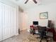 Home office with light gray walls, a ceiling fan, closet, and a wooden desk at 18079 Romanesque Ct, Spring Hill, FL 34610